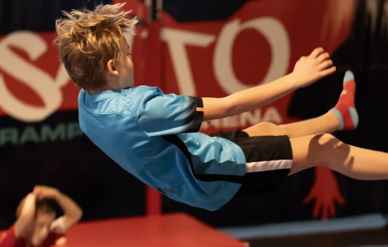 Enfant qui fait un saut en arrière sur trampoline