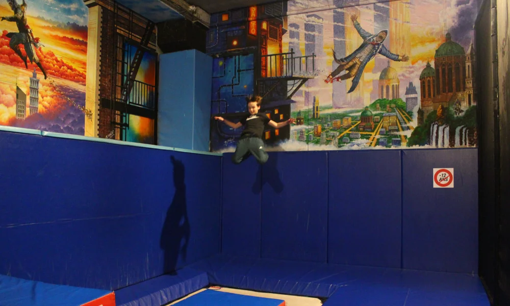 Jeune pratiquant un saut pendant un cours de trampoline chez SALTO
