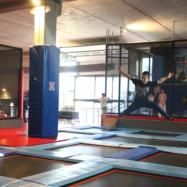 Enfant réalisant un grand écart en saut dans le trampoline park SALTO
